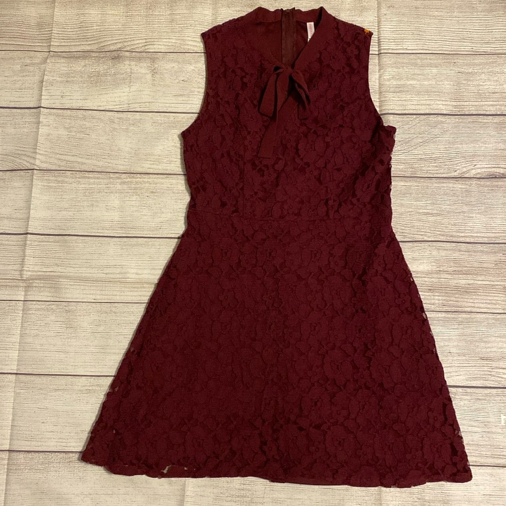 Lace dress with bow tie front and zippered back. Plum/Dark Burgundy colored